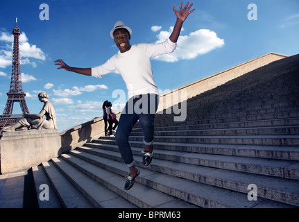 Homme tombant jusqu'au bas de l'escalier près de la tour Eiffel. Banque D'Images