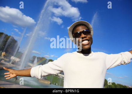 Young man smiling with arms open sur une journée ensoleillée Banque D'Images