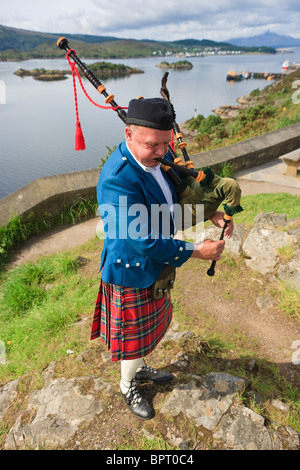 Joueur de cornemuse sur les Highlands écossais, près de l'île de Skye Banque D'Images