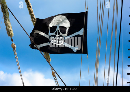 Drapeau pirate, drapeau crâne et Crossbones, drapeau Jolly Roger, drapeau pirate de pirates battant sur un grand voilier historique. Banque D'Images