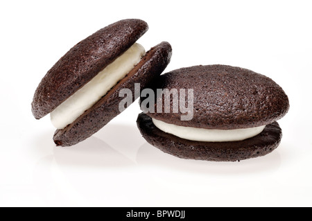 Deux whoopie pie gâteaux farcis à la crème de vanille sur fond blanc, découpe. Banque D'Images