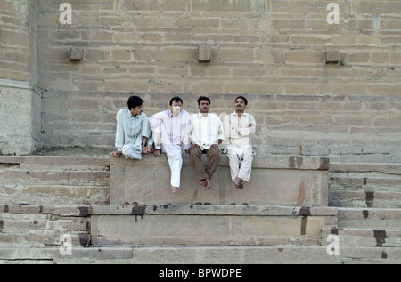 Les hommes assis à un Ghat sur le Gange à Varanasi, Inde Banque D'Images