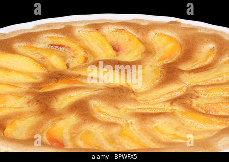 Tarte aux pêches dans une poterie blanche à gâteau. Isolé sur noir avec chemin de détourage. Banque D'Images