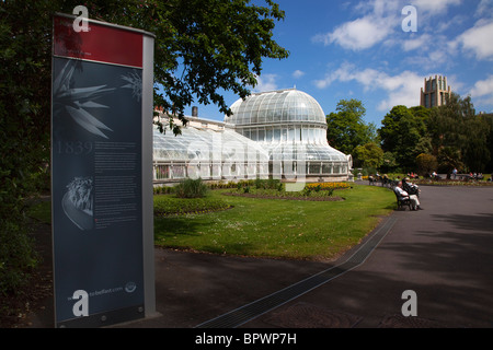 L'Irlande du Nord, Belfast, jardins botaniques, avec des gens assis sur des bancs à l'extérieur de la Palm House à côté de l'Université Queens. Banque D'Images