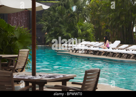 Woman relaxing by piscine du Grand Hyatt Hotel, Hong Kong, Chine Banque D'Images