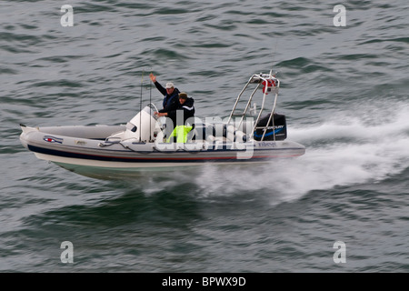 Ribeye bateau gonflable avec un moteur hors bord de mer de mercure à l'arrière faisant de la vitesse. Deux mâles, l'un forme. Banque D'Images