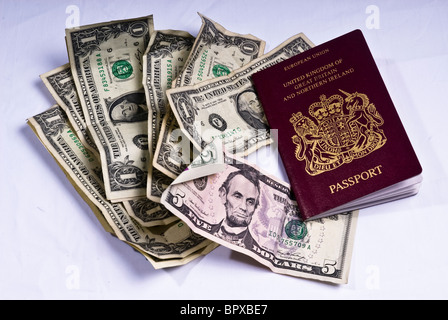 Un passeport du Royaume-Uni portant sur un tas de projets de Dollars américains utilisés Banque D'Images