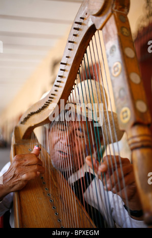 Un artiste de rue aveugle, joue de la harpe comme il chante des chants traditionnels mexicains pour les touristes à Cholula, Mexique, le 20 septembre, 20 Banque D'Images