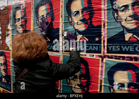 Une femme en face d'un jeu de Sarkozy affiches sur les couleurs du drapeau français (bleu, blanc, rouge), nous pouvons dire "oui" . Banque D'Images