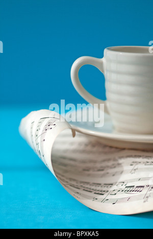 Tasse de café blanc est situé au-dessus de la page musique de curling Banque D'Images