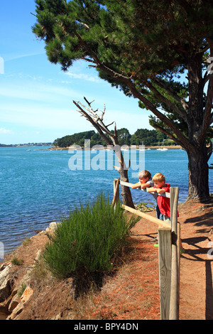 Les garçons à la vue à la mer de de la pointe de Toulindac, Ile aux Moines, Golfe du Morbihan, Bretagne, Bretagne, France Banque D'Images