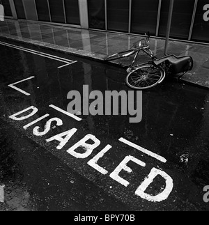 Ville de Londres, où un vélo garé sur un parking gratuit à un pôle a quelque peu baissé au cours de la collecte dans le caniveau. Banque D'Images