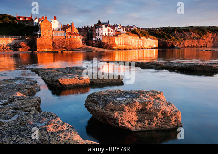 Soleil du matin sur les rochers et du village de Robin Hood's Bay Banque D'Images