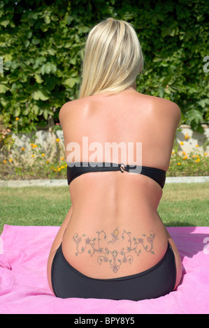 Bas du dos tatouage sur attractive blonde female Banque D'Images