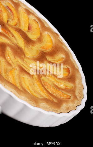 Tarte aux pêches dans une poterie blanche à gâteau. Isolé sur noir avec chemin de détourage. Banque D'Images