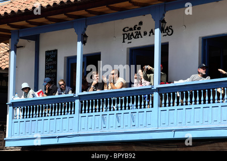 Touristes regardant la vue et se détendre sur le balcon colonial du café dans la place principale Plaza de Armas, Cusco, Pérou Banque D'Images