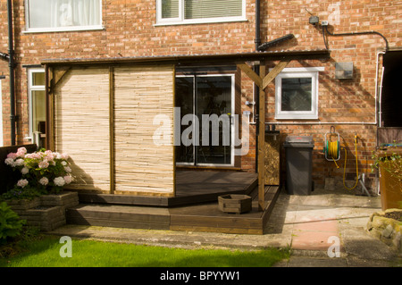 Maison construite en plastique ondulé avec lame de terrasse et de toiture panneaux de dépistage mobile dans un cadre domestique. Manchester, UK. Banque D'Images