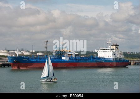Yacht de voile en avant du pétrolier brut, Jade, à quais de Southampton, en Angleterre. Banque D'Images