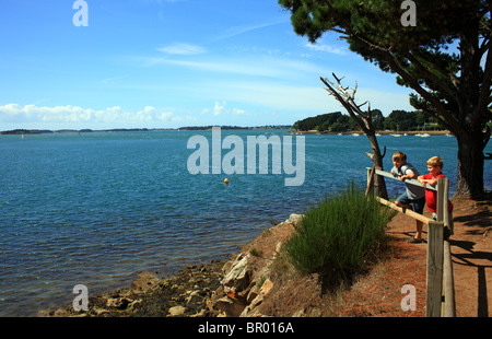 Les garçons à la vue à la mer de de la pointe de Toulindac, Ile aux Moines, Golfe du Morbihan, Bretagne, Bretagne, France Banque D'Images