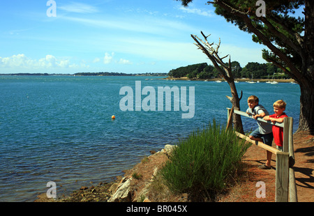 Les garçons à la vue à la mer de de la pointe de Toulindac, Ile aux Moines, Golfe du Morbihan, Bretagne, Bretagne, France Banque D'Images