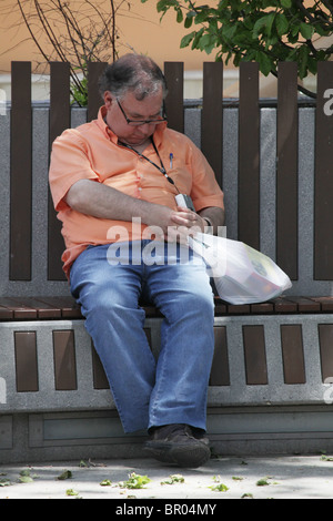 Chubby middle-aged man sam dormir dans place publique pendant siesta à Puigcerda Catalogne Espagne Banque D'Images