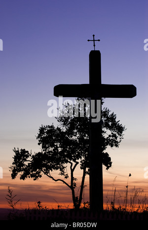 Croix de bois en bordure de symbole avant que bush catholique. En arrière-plan on peut voir le coucher du soleil coloré Banque D'Images