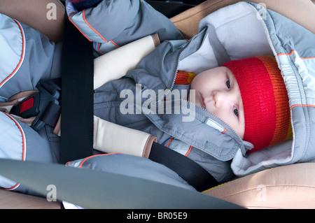 L'enfant dormir dans un siège de sécurité sur l'avant de la voiture assis Banque D'Images