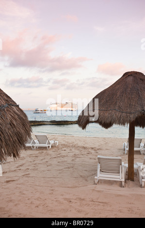 Mexique, Cozumel. Parasols sur la plage et bateau de croisière, San Miguel, Isla Cozumel, île de Cozumel. Banque D'Images