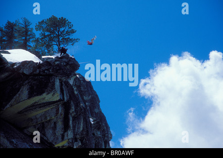 Snowboard-BASE jumper faisant un saut d'une falaise près du lac Tahoe. Banque D'Images