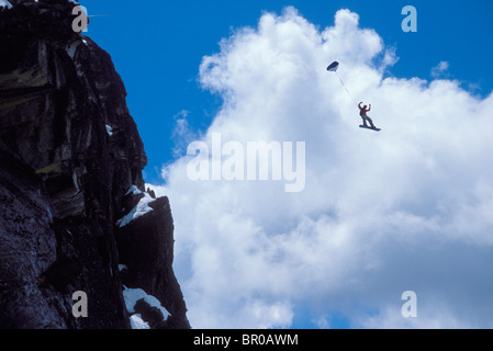 Snowboard-BASE jumper faisant un saut d'une falaise près du lac Tahoe. Banque D'Images