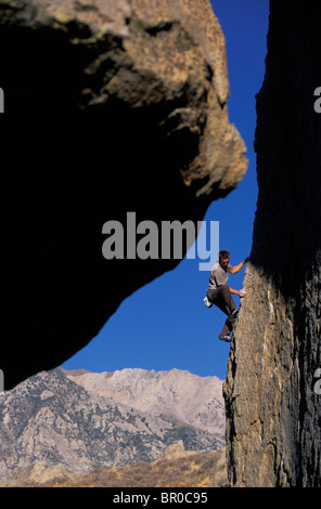 Un homme bouldering lors d'une journée ensoleillée dans le désert. Banque D'Images