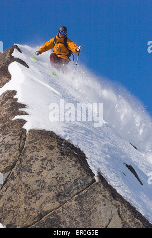 Un homme ski poudreuse sur un rocher sur le Sommet Donner en Californie. Banque D'Images