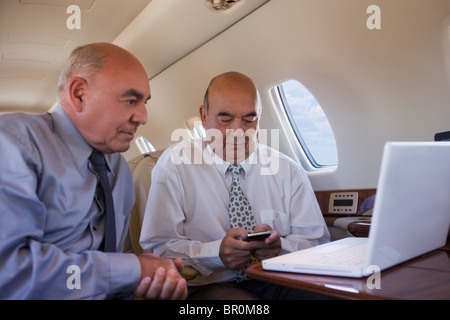 Business people working on private jet Banque D'Images