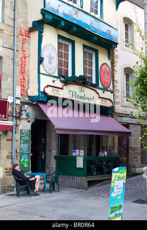 Fille assise à l'extérieur d'un bar à Lannion dans les Côtes-d'Armor de la Bretagne, dans le nord-ouest de la France. Banque D'Images