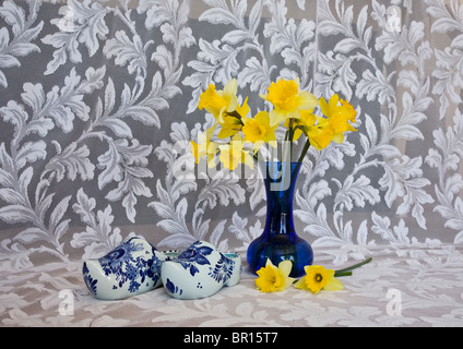 Jardin intérieur vintage avec fenêtre, vase jonquille à fleurs jonquille, sabots hollandais en céramique Delft, détail rideaux en dentelle, New Jersey, États-Unis, contenant Banque D'Images