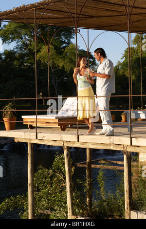 Un couple ayant un verre sur un pont à Carmelo, Uruguay. Banque D'Images