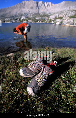 Homme se lavant le visage dans un lac de montagne dans les montagnes de l'est de la Sierra Nevada, Californie. Banque D'Images