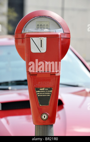 Parking meter rouge sur rue du centre-ville. Banque D'Images