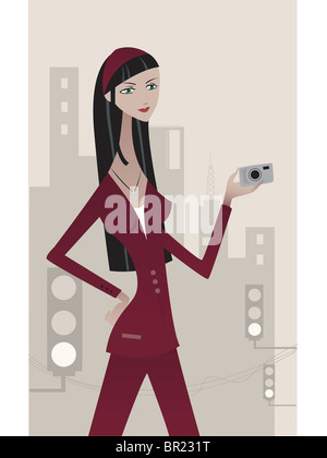Une femme en bourgogne suit holding digital camera Banque D'Images