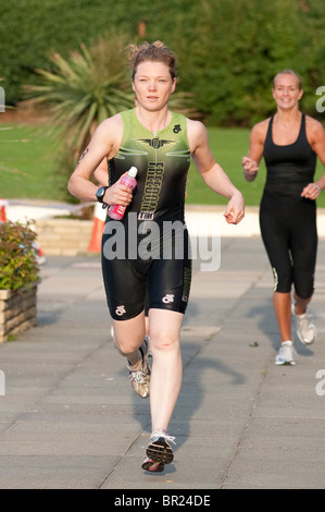 Une femme de triathlète club Tri la liberté s'étend de l'aire de transition après un 400m de natation Banque D'Images