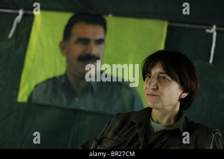 Portrait de l'Union des communautés du Kurdistan (KCK) Membre du Conseil exécutif Sozdar Avesta avec la figure de l'ancien militant du PKK, Abdullah Ocalan, leader en arrière-plan dans un camp du nord de l'Iraq hideout PKK Banque D'Images