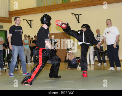 La lutte contre les concurrents dans un tournoi de kickboxing Banque D'Images