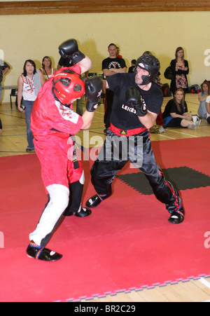 La lutte contre les concurrents dans un tournoi de kickboxing Banque D'Images