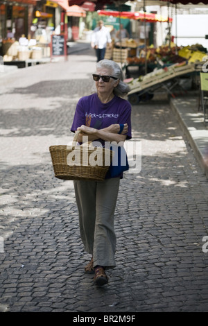 Une femme avec son panier de promenades à travers le marché sur la Rue Mouffetard, un célèbre marché alimentaire à Paris Banque D'Images