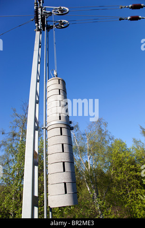 Contrepoids en béton suspendus à un système de poulie qui maintient les câbles électriques du chemin de fer serrés et en tension correcte , Finlande Banque D'Images