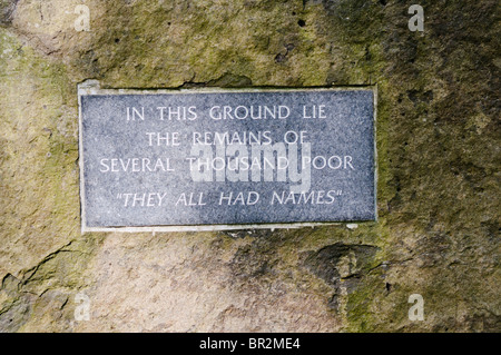 Plaque sur une très grande pierre dire "dans ce sol reposent les restes de plusieurs milliers de pauvres. Ils avaient tous des noms Banque D'Images