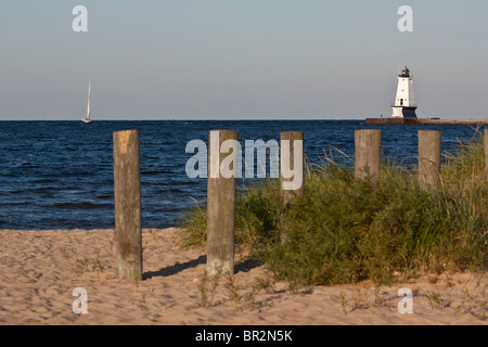 Phare blanc et rangée de piquets en bois dans la plage de sable eau bleu ciel paysage hors horizon personne Lac Michigan à MI aux États-Unis Grands Lacs haute résolution Banque D'Images