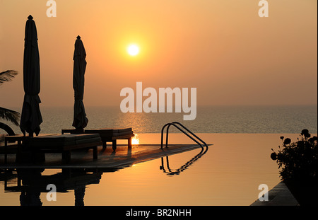 Piscine à débordement de l'hôtel au coucher du soleil, Kovalam, Kerala, Inde Banque D'Images