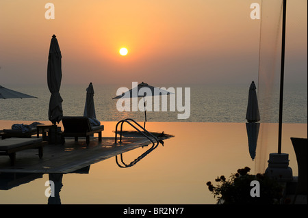 Piscine à débordement de l'hôtel au coucher du soleil, Kovalam, Kerala, Inde Banque D'Images