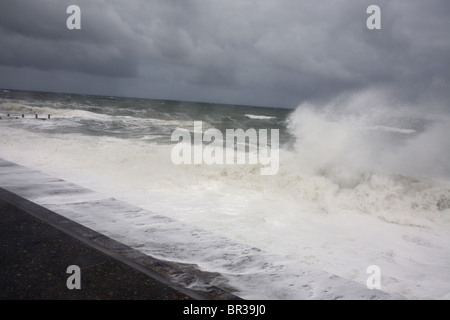 Mer Agitée vagues se briser contre un mur de la mer sur la côte de Norfolk. Banque D'Images